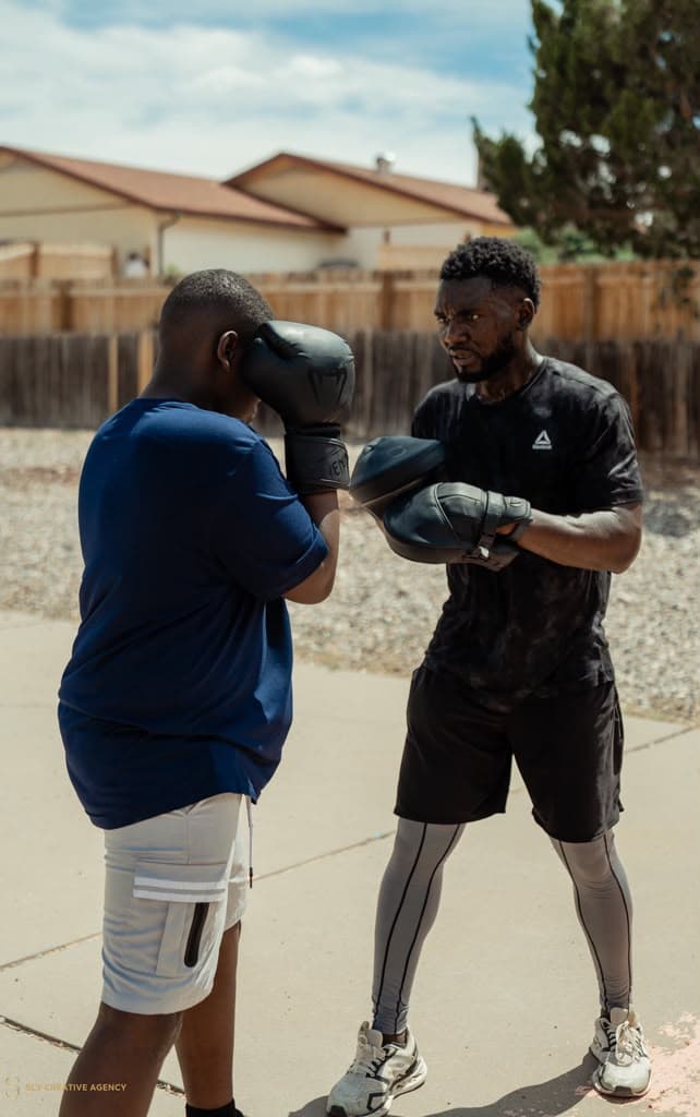 Coach helping a youth boxer build confidence and discipline
